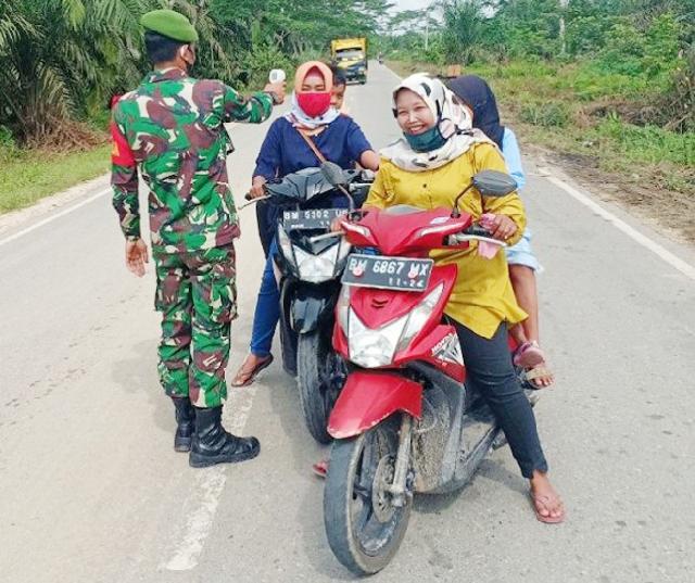 Babinsa Rawa Makmur Ukur Suhu Tubuh Pengendara di Jalan Lintas Pasir Pengaraian